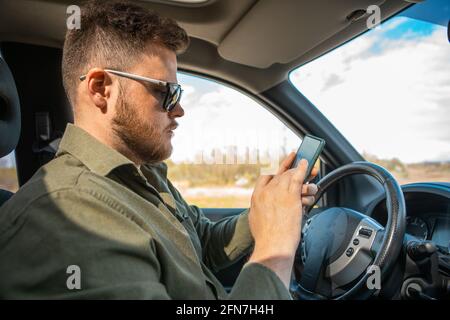 man sitting in car using phone distracted lifestyle Stock Photo