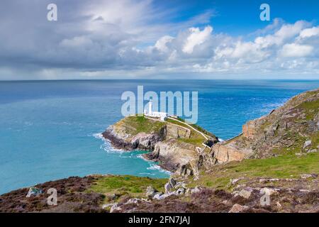 South Stack Lighthouse, Anglesey, in sunshine, but with mixed weather out to sea. Stock Photo