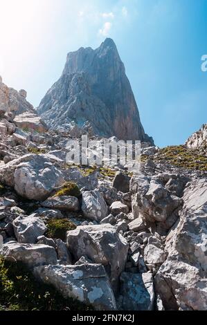 Photograph taken from the base of Picu Urriellu or Naranjo de Bulnes, with the huge stones in the foreground as you arrive.The photo was taken on a su Stock Photo