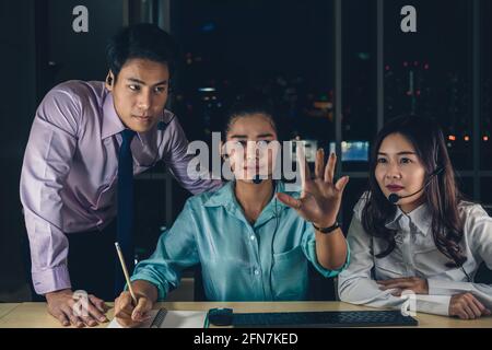 Group of business People working hard late with her technology computer in office at night, Customer service and Working hard for success achievement Stock Photo