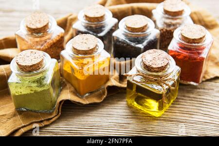 Jars with dried herbs, spices on the table Stock Photo