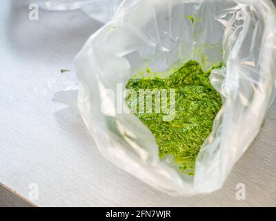 Ramson pesto in freezing bag. Chopped herbs with  ingredients for cooking it on a wooden table Stock Photo