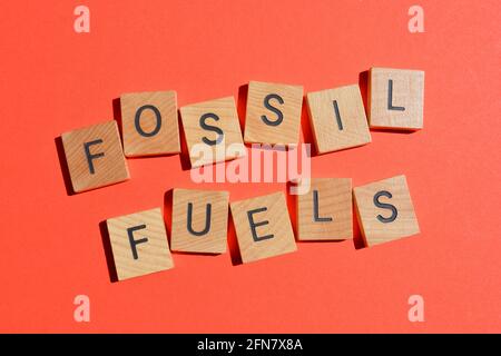 Fossil Fuels, word in wooden alphabet letters isolated on red background Stock Photo