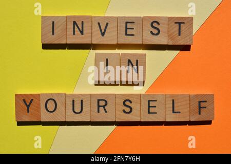 Invest In Yourself, phrase in wooden alphabet letters isolated on colourful background