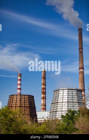 Pavlodar thermal electric station. Smoke stacks with white smoke. Cooling towers on foreground. Stock Photo
