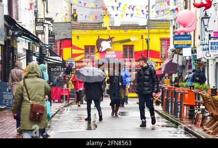 Brighton UK 15th May 2021 - Umbrellas are out in force in Brighton as wet weather sweeps across most parts of Britain today : Credit Simon Dack / Alamy Live News Stock Photo