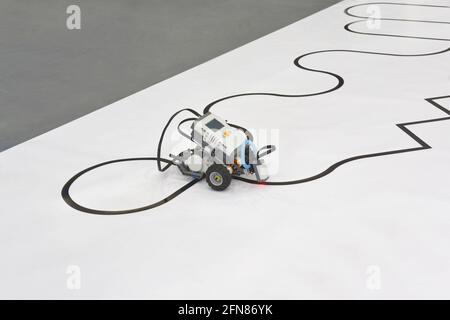 Programmable four wheels robotic car with line follow ability. robot driving on a line on white background with clipping path Stock Photo