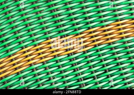 Green plastic woven background with a yellow diagonal line Stock Photo