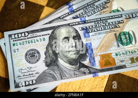 Dollar bills on old chessboard, US paper currency and chess game. Concept of money strategy, unfair competition, bets, sports betting, gamble, stock m Stock Photo