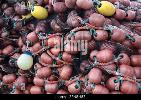 bunch of brown and yellow fishing net floats of piled up fishing nets Stock Photo