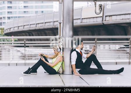 Two people with unique difference lifestyle compare both sport girl and businessman using smartphone. Stock Photo