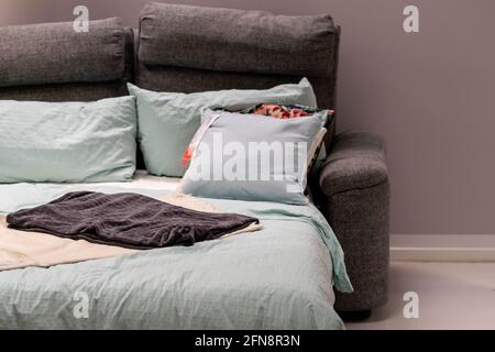 Sofa bed with colorful pillows on sale from a store Stock Photo