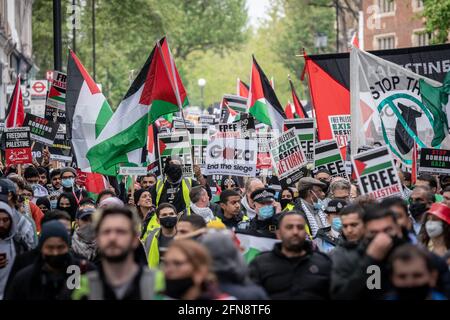 London, UK. 15th May, 2021. Pro-Palestinian demonstrators march through central London holding signs and flags on Nakba Day. Thousands march towards the Israeli Embassy to rally in solidarity with the people of Palestine. At least 139 people have been killed in Gaza, including 39 children, after a spiral of violence that began with the eviction of Arabs from the Sheikh Jarrah neighbourhood in East Jerusalem. Credit: Guy Corbishley/Alamy Live News Stock Photo