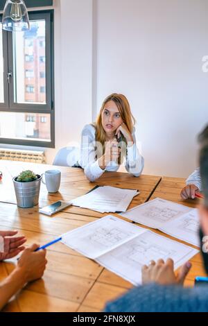 Businesswoman in a work meeting looking blueprints Stock Photo