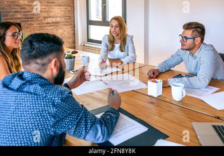 Businesspeople in a meeting looking at construction drawings Stock Photo