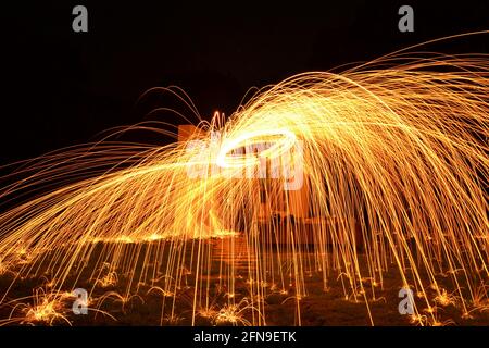 Sparkling photo painting with steel wire in nature at night connected on string with centrifugal movements Stock Photo