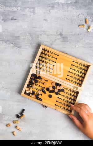 Board for playing backgammon with pieces and dice on a stone background. Top view Stock Photo