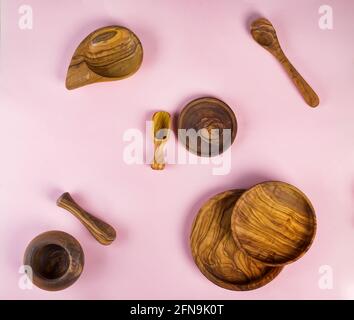 Set of wooden kitchen utensils made from olive wood on pink background, flat lay Stock Photo