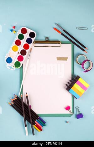 Clipboard and office or school supplies over blue background, flat lay. Back to school Stock Photo