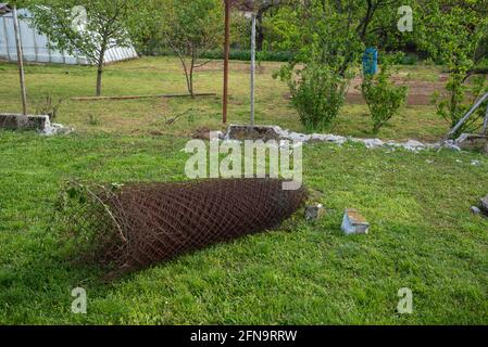 Demolition of an old mesh fence with a small concrete wall Stock Photo