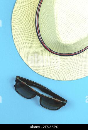 Summer blue background with straw tropical hat and sunglasses for a travel Stock Photo