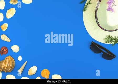Summer holiday round background composition with seashells and straw hat on a blue table, copy space anf flat lay Stock Photo
