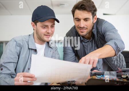 man working with apprentice in printing house Stock Photo
