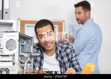 technician fitting component into computer Stock Photo
