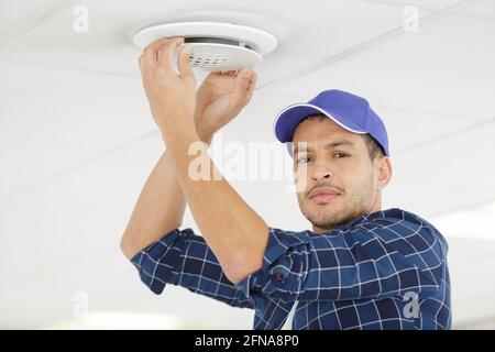 male technician installing ceiling fan Stock Photo