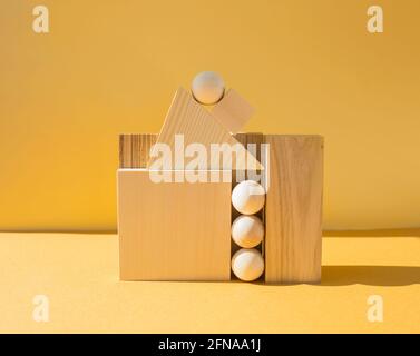 Geometric composition of wooden figures on yellow background Stock Photo