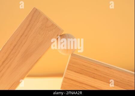 Wooden ball between two wooden blocks. Stock Photo