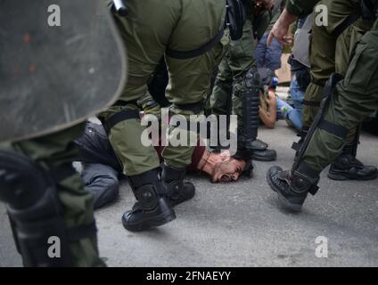 Riot police arrest a pro-palestinian demonstrator amidst clashes with the police during a solidarity rally with the Palestinians, called over the ongoing conflict with Israel, outside the Israeli embassy, in Athens, Greece, on May 15, 2021. Rallies are taking place today all over the world to mark Nakba Day and voice support for Palestinians. Credit: Dimitris Aspiotis / Alamy Stock Photo