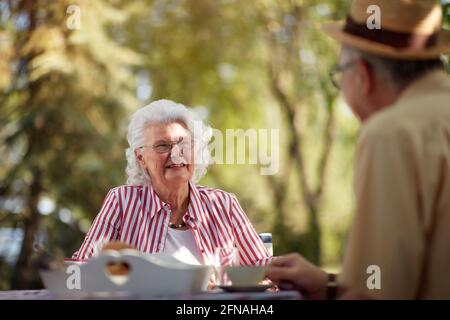 beautiful elderly caucasian couple enjoy outdoor, having breakfast and coffee Stock Photo