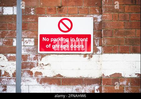 No parking in front of garage doors red sign Stock Photo