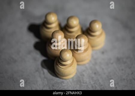 triangle tightly shifted chess pieces of six pawns. Teamwork, close-knit teams Stock Photo