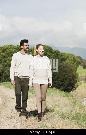 Happy young couple walking through the countryside Stock Photo