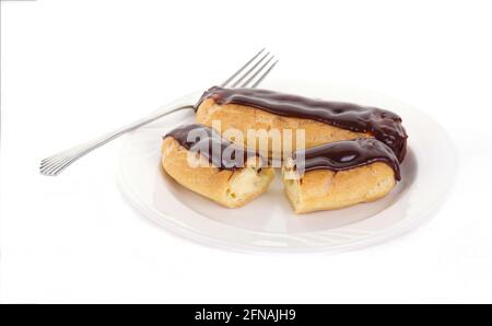 Two Chocolate Eclairs on a White Plate with a Fork Stock Photo