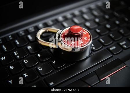 Closeup of a combination lock on a black keyboard. Stock Photo