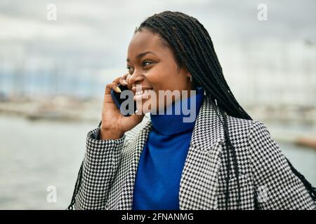 Young african american businesswoman smiling happy talking on the smartphone at the port. Stock Photo