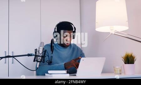 Man wearing headphones taking an online using a laptop and microphone . High quality photo Stock Photo