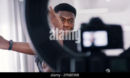 Black guy doing arm stretches warming up before a workout in front of a camera. High quality photo Stock Photo