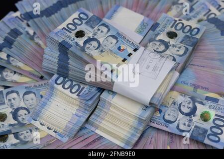 A pile of one thousand Philippines banknotes. Cash of Thousand dollar bills, Peso background image. Stock Photo