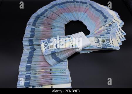 A pile of one thousand Philippines banknotes. Cash of Thousand dollar bills, Peso background image. Stock Photo