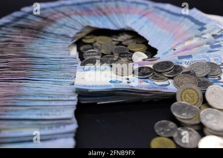 A pile of one thousand Philippines banknotes and coins Stock Photo