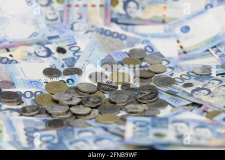 A pile of one thousand Philippines banknotes and coins Stock Photo