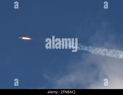 Cape Canaveral, United States. 15th May, 2021. As seen from Playalinda Beach at Canaveral National Seashore, a SpaceX Falcon 9 rocket carrying the 28th batch of satellites for SpaceXs Starlink broadband network launches from pad 39A at the Kennedy Space Center. In addition to 52 Starlink satellites, the rocket is also carrying rideshare payloads for Capella Space and Tyvak Nano-Satellite Systems. Credit: SOPA Images Limited/Alamy Live News Stock Photo