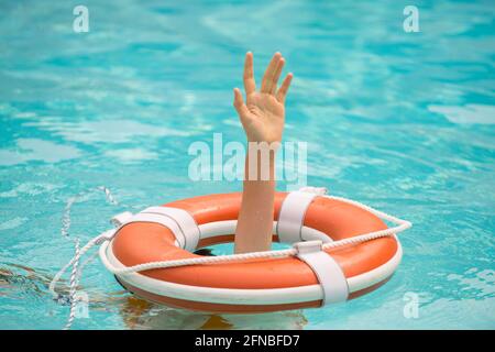 Helping hand. Life problems. Drowning person. Rescue swimming ring in water. Safety water equipment. Stock Photo