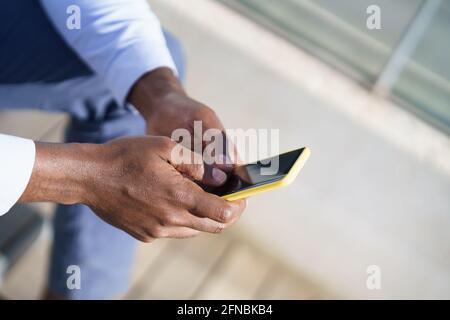 Hands of unrecognizable black man using a smartphone. Stock Photo
