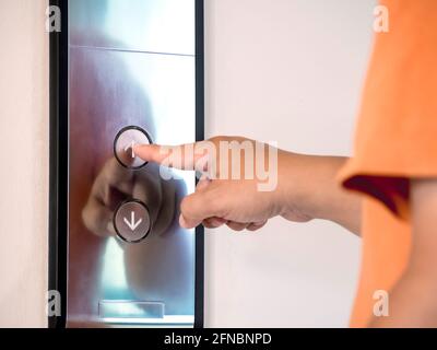 The finger of male pressing the elevator or lift button for next level up in apartment or condominium. More advance to success concept. Stock Photo
