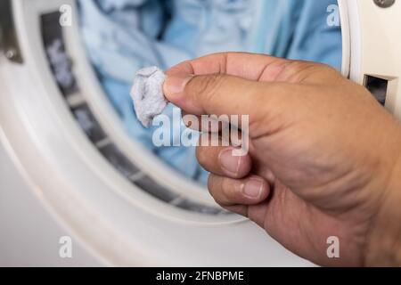 Hand removing lint from fabric trapped on laundry dryer filter Stock Photo